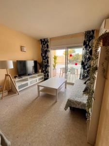 a living room with a couch and a tv and a table at Cap Salou Sea View in Salou