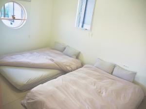 two beds sitting next to each other in a room at 「淡路島一棟貸宿　野うさぎ 」高台から海を望む貸別荘！2023年新築離れの素泊まり in Noda