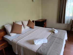 a bedroom with a large bed with two towels on it at Shalom in Peradeniya