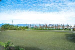 a large grass field with a blue sky and clouds at 7star in Guilin