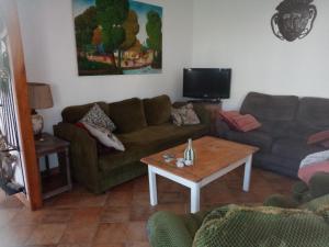 een woonkamer met een bank en een salontafel bij La campagne au bord de la mer, chambre chez l'habitant in Champeaux