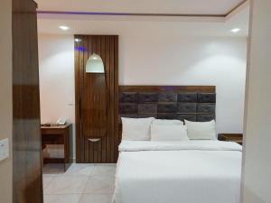 a bedroom with a large white bed and a desk at The Seasons Apartment Kado in Abuja