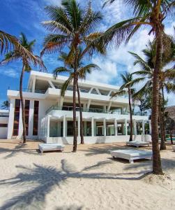 a building on the beach with palm trees at Barracuda Inn Resort in Watamu