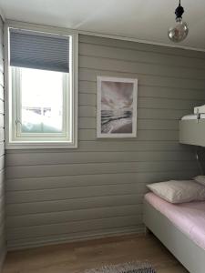1 dormitorio con paredes grises y ventana en Oppdal Alpintun ski in ski out, en Oppdal