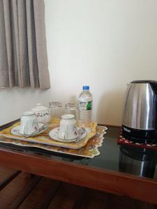 a table with a tea set and a coffee maker at Shalom in Peradeniya
