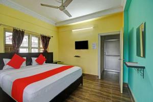 kolkata的住宿－Goroomgo Salt Lake Palace Kolkata - Fully Air Conditioned & Parking Facilities，一间卧室配有一张带红色枕头的大床