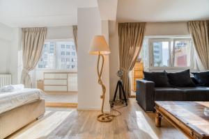 ブカレストにあるVictoriei Elite Apartments-Free Minibarのリビングルーム(ベッド1台、ソファ付)