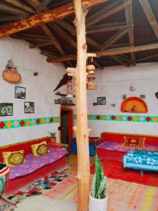 una sala de estar con 2 camas y un árbol en l'expérience Berbère, en Agadir