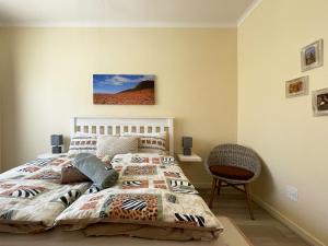 1 dormitorio con 1 cama y 1 silla en Anka's Cozy Holiday Home, en Swakopmund