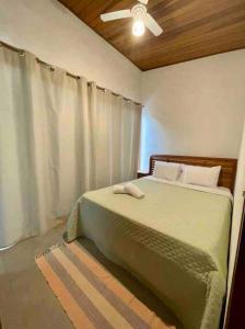 a bedroom with a bed with a ceiling fan at Camburi Beach House - Casa térrea a 50 m da praia in São Sebastião