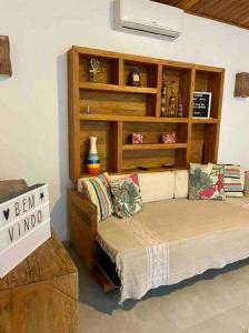a bedroom with a bed and a book shelf at Camburi Beach House - Casa térrea a 50 m da praia in São Sebastião
