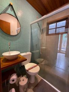 a bathroom with a toilet and a sink and a shower at Camburi Beach House - Casa térrea a 50 m da praia in São Sebastião