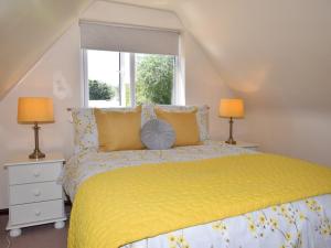 um quarto com uma cama amarela e 2 candeeiros em 2 Bed in Lyndhurst 75879 em Totton
