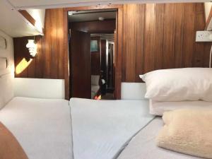 um quarto com 2 camas brancas e uma parede de madeira em Marina Oasis, Your Boatel em Puerto Calero