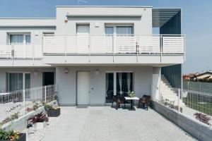 a white house with a balcony and a table at The Prince - Luxury apartments with Pool in Peschiera del Garda