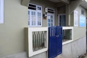 een gebouw met een blauwe deur aan de zijkant bij Hotel New Smriya Homestay Inn Darjeeling in Darjeeling