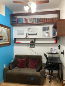 uma sala de estar com um sofá e uma secretária em Apartamento aconchegante no Hotel Quitandinha em Petrópolis