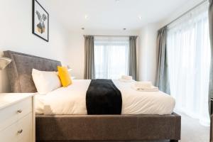 a bedroom with a large bed with a large window at Leeds City Centre Duplex 3 Bedroom 3 Bath stunning Flat with Rooftop Terrace and Parking in Leeds