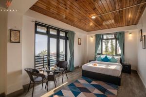 a bedroom with a bed and a table and chairs at Zostel Rinchenpong (Pelling) in Rinchingpong