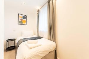 two beds in a room with a window at Leeds City Centre Duplex 3 Bedroom 3 Bath stunning Flat with Rooftop Terrace and Parking in Leeds