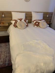 een groot wit bed met vier kussens erop bij Appartement Cosy et chaleureux in Montreuil