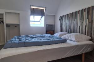 1 cama con edredón azul y 2 almohadas en Tipi des dunes, en Surtainville