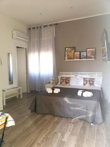 a bedroom with a large bed and a large window at Casa Ibla in Siracusa
