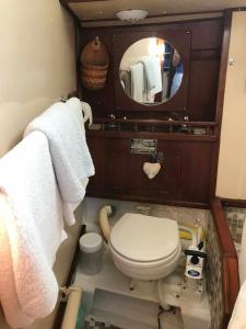 a small bathroom with a toilet and a mirror at Marina Oasis, Your Boatel in Puerto Calero
