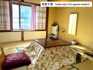Una habitación con una cama con una mesa. en Takasagoya Ryokan en Zao Onsen