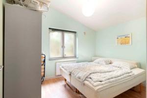 a bedroom with a bed and a window at Large Cottage In Peaceful, Beautiful Nature in Mølby