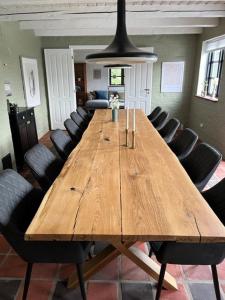 einen großen Holztisch in einem Zimmer mit Stühlen in der Unterkunft Oustrupgård in Egtved