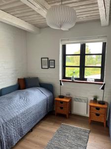 Schlafzimmer mit einem Bett und einem Fenster in der Unterkunft Oustrupgård in Egtved