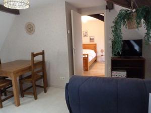 un salon avec un canapé et une table ainsi qu'une chambre dans l'établissement Bel Appartement aux portes de l’Auxois-Morvan, à Précy-sous-Thil