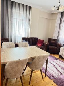 uma sala de estar com uma mesa de madeira e cadeiras em Konfor ve huzurunuz için her şey var klimasız oda em Antalya