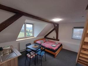 a bedroom with a bed and a table and chairs at Ubytování v soukromí HONELI in Velká Štáhle