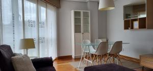 sala de estar con mesa de cristal y sillas en Apartamento en Coruña con parking, en A Coruña