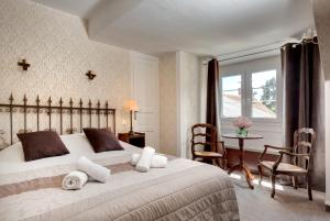 een slaapkamer met een bed en een tafel met stoelen bij Hotel La Roseraie in Chenonceaux