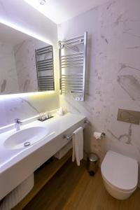 La salle de bains est pourvue d'un lavabo, de toilettes et d'un miroir. dans l'établissement Les Terrasses du Port, à Saint-Pierre