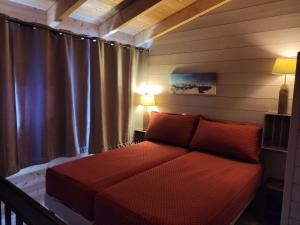a bedroom with a red couch in a room at Appartement Huez, 2 pièces, 6 personnes - FR-1-405-89 in L'Alpe-d'Huez