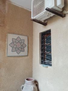 a vase sitting next to a wall with a window at Venus house15 in Raoued