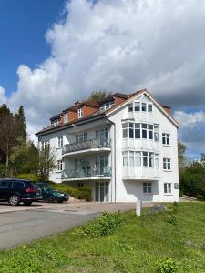 グレーミッツにあるGrüntal-Residenz Haus I App. 5の駐車場車が停まった白い建物