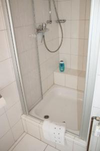ein Bad mit einer Dusche und Toilettenpapier in der Unterkunft Haus Rika 2 in Neuharlingersiel