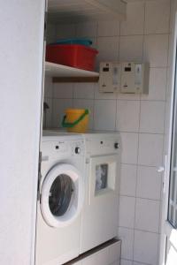 Waschmaschine und Trockner in einer kleinen Küche in der Unterkunft Haus Rika 2 in Neuharlingersiel