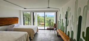シルカシアにあるCasa Piamonte Quindíoのベッドルーム1室(ベッド2台付)、景色を望む窓が備わります。
