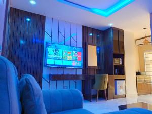 a living room with a tv on a wall at The Seasons Apartment Kado in Abuja