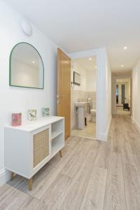 Baño blanco con lavabo y espejo en Stylish Beach Front Retreat en Kent