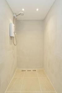 baño con ducha y teléfono en la pared en Stylish Beach Front Retreat en Kent