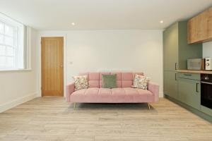 a pink couch sitting in a living room at Stylish Beach Front Retreat in Kent