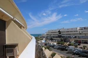 einen Blick vom Balkon eines Gebäudes mit einem Parkplatz in der Unterkunft Studio 34, Héliopolis E au village naturiste in Cap d'Agde