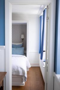 um quarto com paredes azuis e uma cama com cortinas azuis em Arnfeldt Hotel & Restaurant em Ærøskøbing